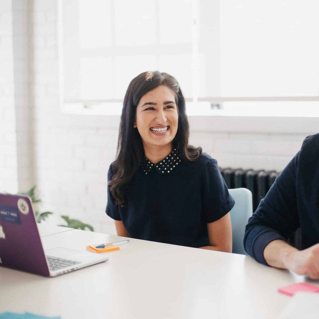 woman sitting in front of computer smiling