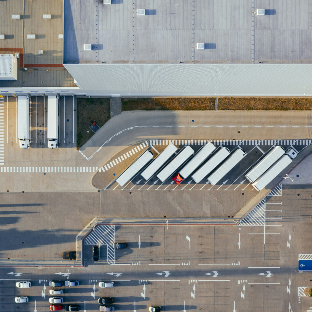 aerial view of distribution center featuring a warehouse and semi trucks