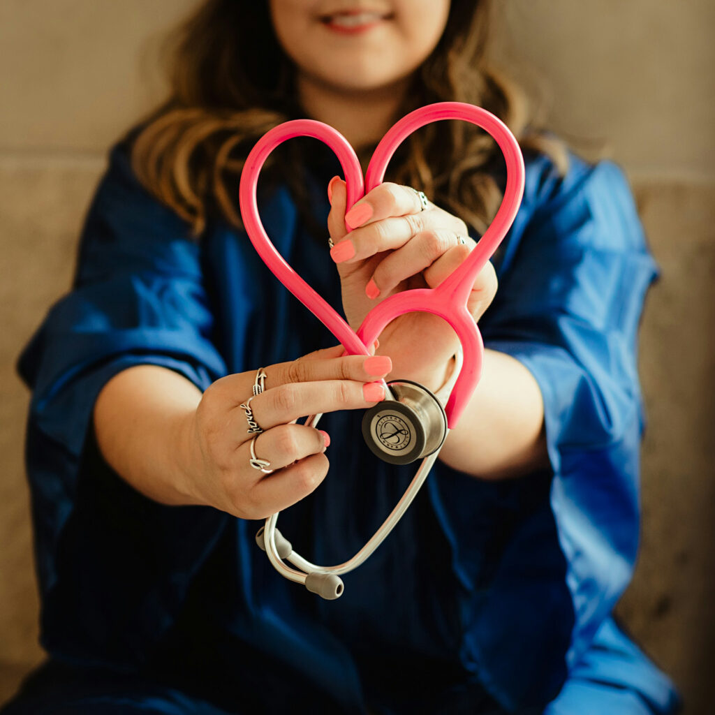 woman holding a stethoscope forming it into a heart shape